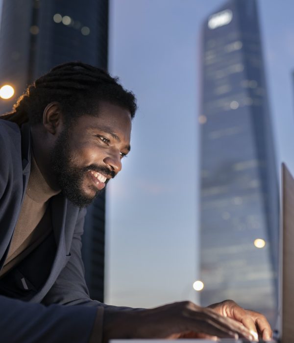 businessman with laptop at night buildings